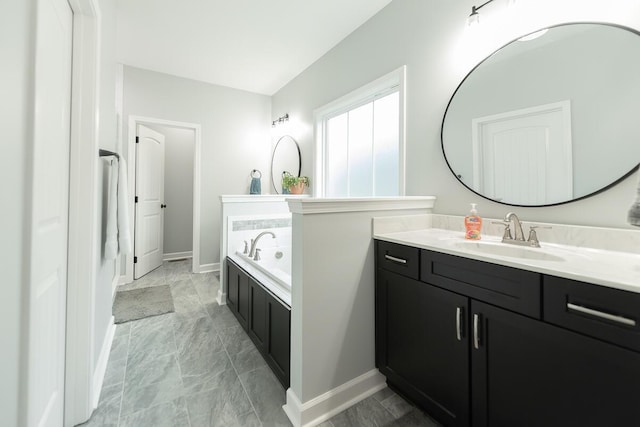 full bathroom with a bath, vanity, and baseboards