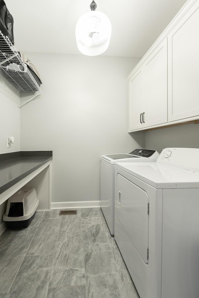 laundry room featuring cabinet space, baseboards, and separate washer and dryer