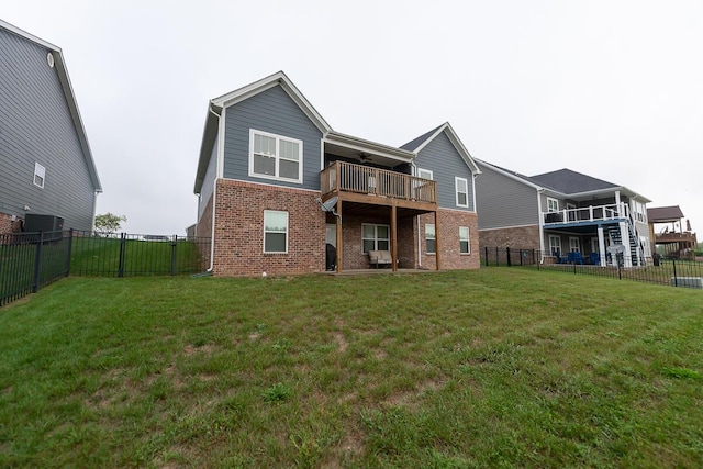 back of house featuring brick siding, a lawn, a fenced backyard, and a ceiling fan