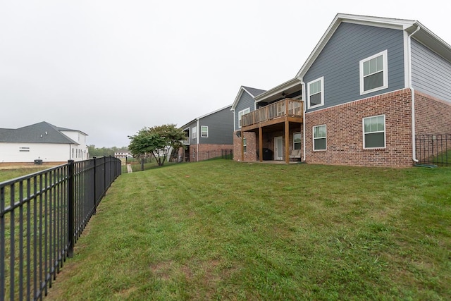 back of house with a fenced backyard, a lawn, and brick siding