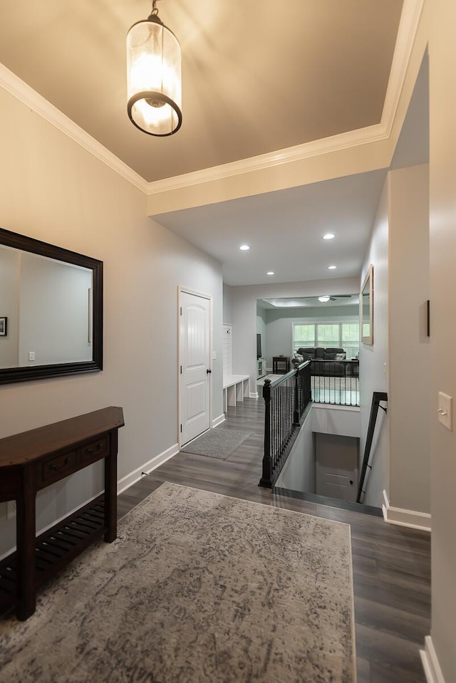 hall featuring baseboards, crown molding, and an upstairs landing