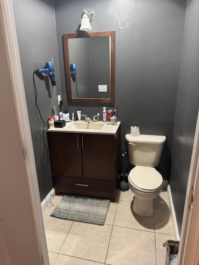 bathroom with tile patterned flooring, vanity, and toilet