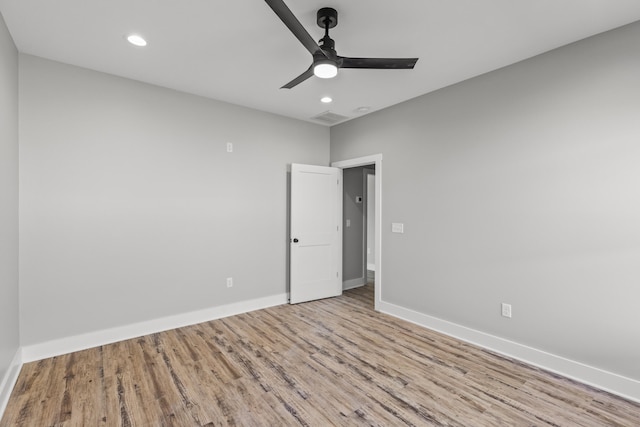 spare room with ceiling fan and light wood-type flooring