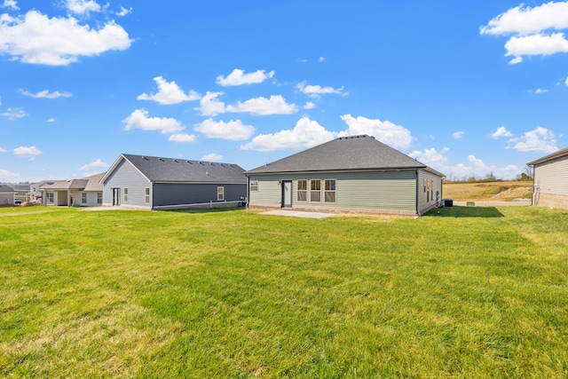 rear view of property featuring a yard and a patio area