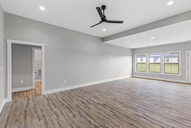 empty room with ceiling fan and light hardwood / wood-style flooring