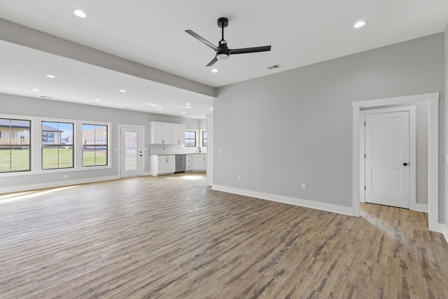 unfurnished living room featuring ceiling fan and light hardwood / wood-style flooring