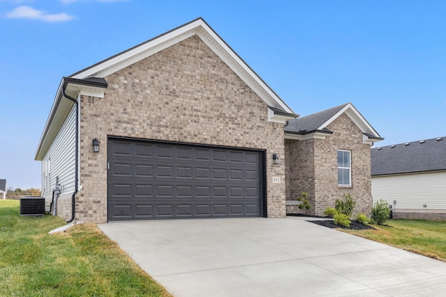 view of front of home featuring a garage, central air condition unit, and a front lawn