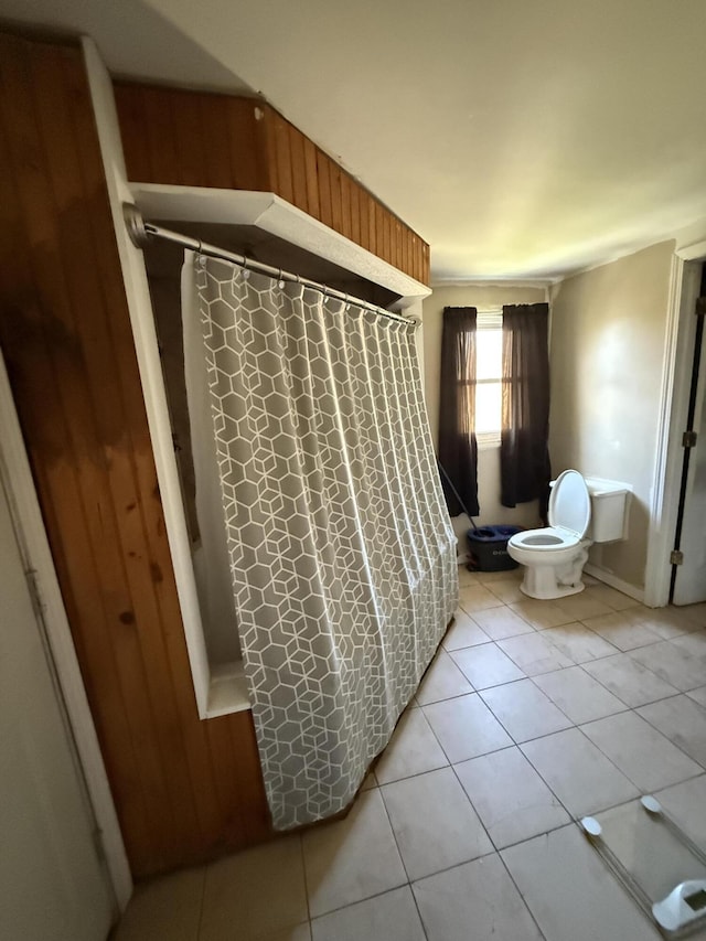 bathroom with tile patterned floors, toilet, and walk in shower