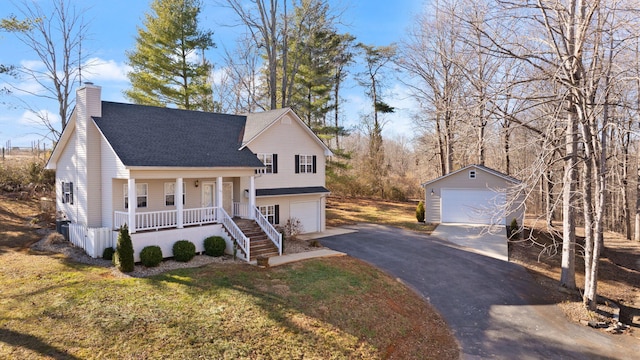 view of front of house featuring a porch, a garage, a front yard, and an outdoor structure