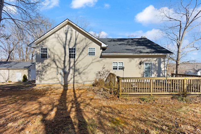 back of property with a wooden deck and a shingled roof