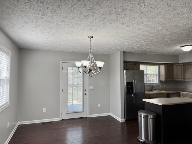 kitchen featuring visible vents, stainless steel fridge, a sink, dark wood-style flooring, and light countertops