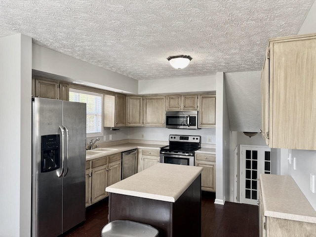 kitchen with a center island, a sink, light countertops, appliances with stainless steel finishes, and dark wood-style floors