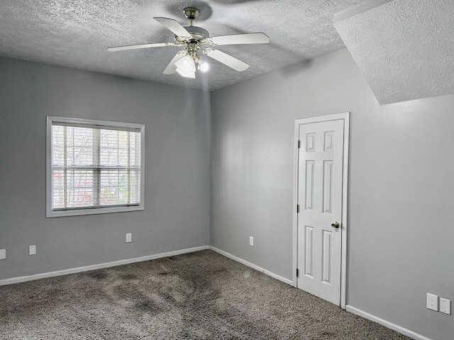 spare room with a textured ceiling, ceiling fan, baseboards, and carpet