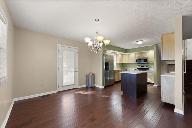 kitchen featuring a kitchen island, decorative light fixtures, dark hardwood / wood-style flooring, stainless steel appliances, and an inviting chandelier