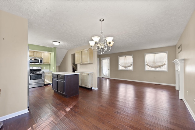 kitchen with a healthy amount of sunlight, appliances with stainless steel finishes, a center island, and decorative light fixtures