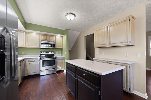 kitchen with stainless steel appliances, a center island, a textured ceiling, and dark hardwood / wood-style flooring