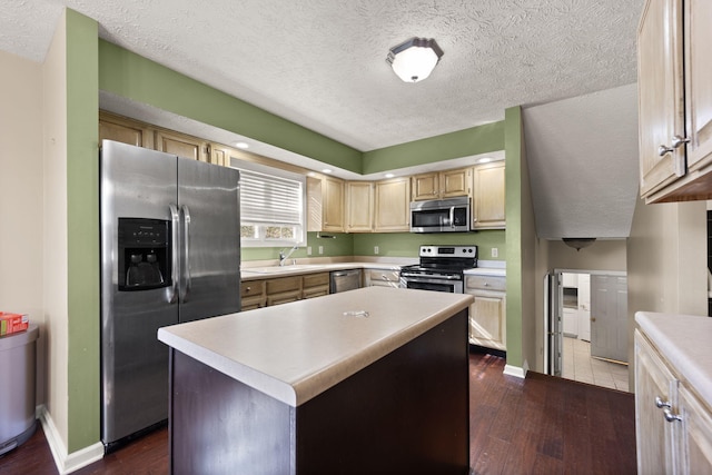 kitchen featuring sink, dark hardwood / wood-style flooring, a center island, stainless steel appliances, and a textured ceiling