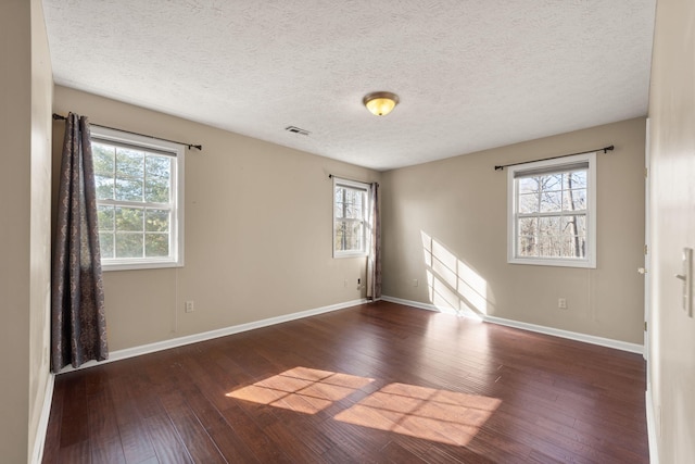 spare room with dark hardwood / wood-style flooring and a textured ceiling