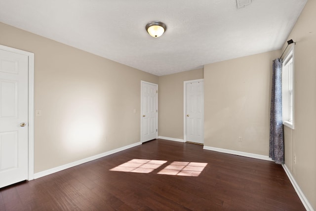 spare room with dark hardwood / wood-style flooring and a textured ceiling