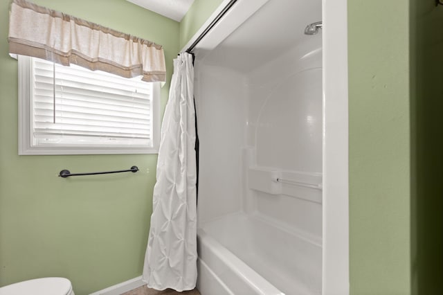 bathroom with toilet and shower / bath combo with shower curtain