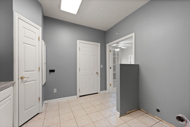 clothes washing area with light tile patterned floors, baseboards, ceiling fan, laundry area, and electric dryer hookup