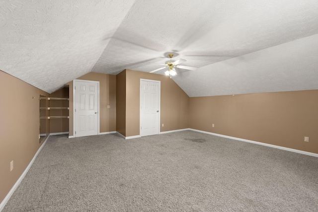 additional living space with ceiling fan, carpet floors, a textured ceiling, and vaulted ceiling