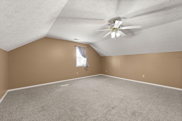 bonus room with ceiling fan, lofted ceiling, carpet floors, and a textured ceiling