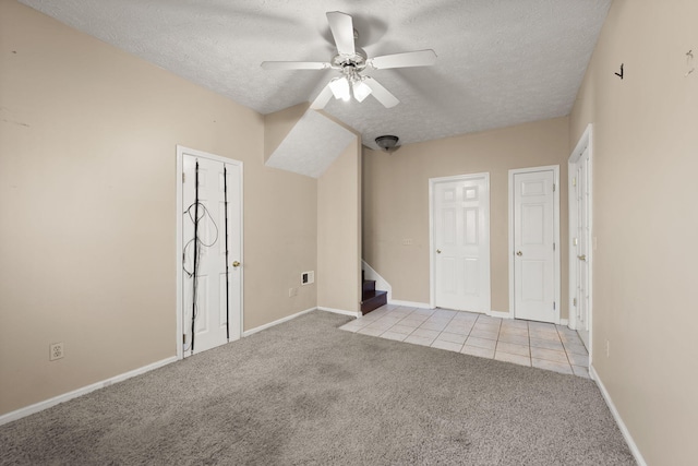 unfurnished room featuring ceiling fan, light carpet, and a textured ceiling