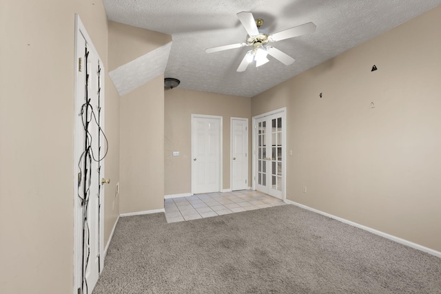 carpeted empty room with french doors, ceiling fan, and a textured ceiling