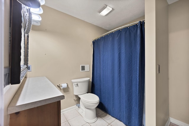 bathroom with tile patterned flooring, vanity, a textured ceiling, and toilet