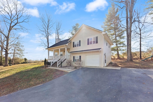 view of front facade with a porch, a chimney, aphalt driveway, and a garage