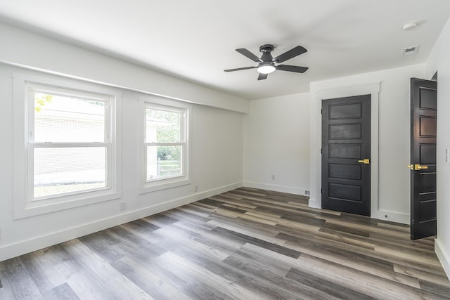 empty room with ceiling fan and dark hardwood / wood-style flooring