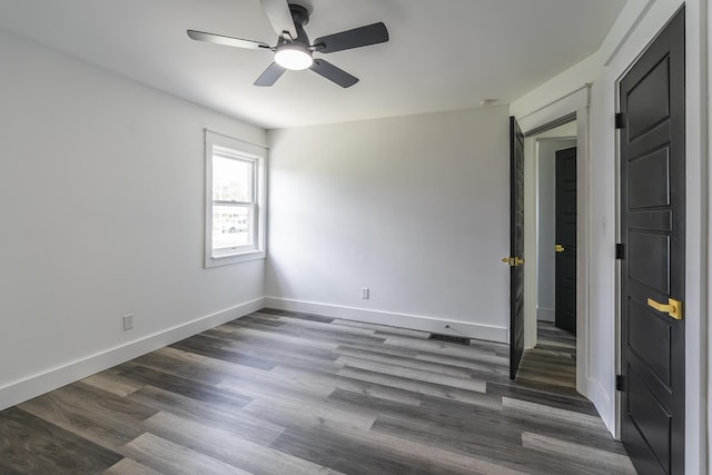 unfurnished room with dark hardwood / wood-style floors and ceiling fan