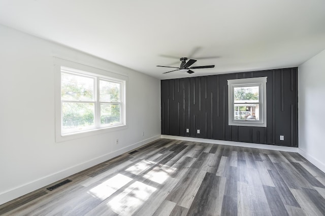 empty room featuring hardwood / wood-style flooring, a healthy amount of sunlight, and ceiling fan