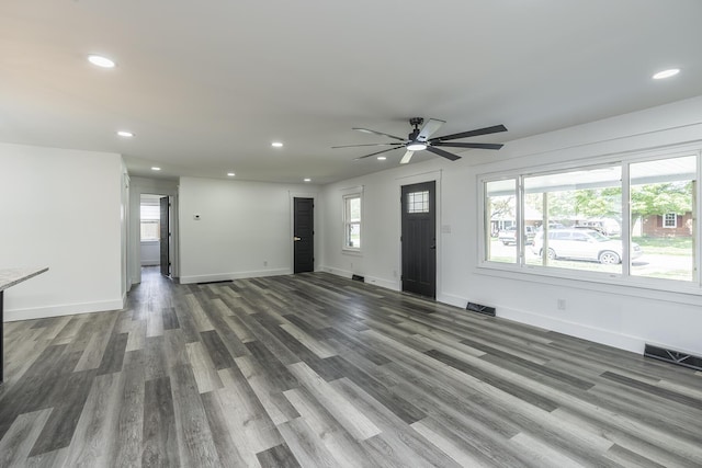 unfurnished living room with ceiling fan and dark hardwood / wood-style flooring