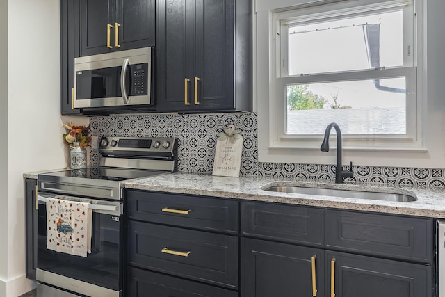 kitchen featuring light stone counters, sink, backsplash, and stainless steel appliances