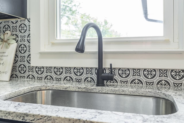 interior details featuring light stone counters and sink