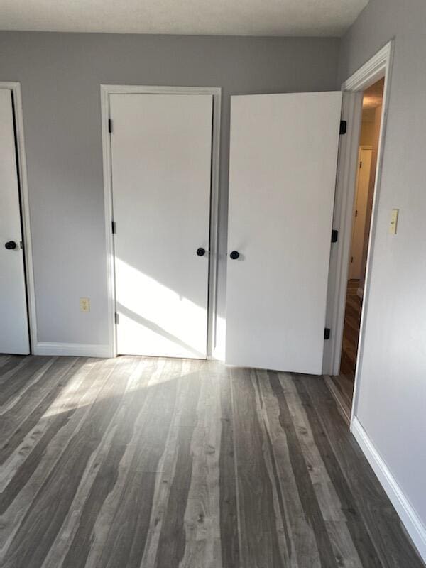 unfurnished bedroom with baseboards and wood finished floors