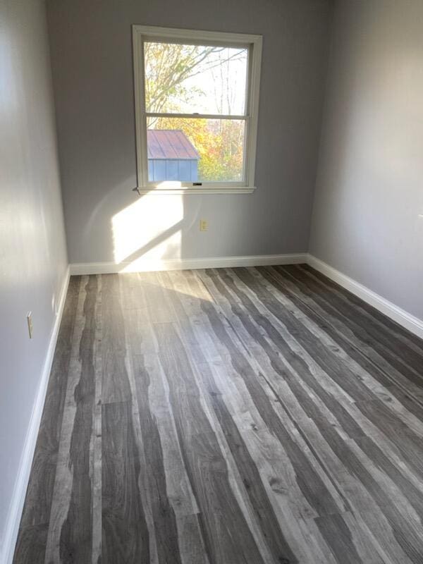 empty room with wood finished floors and baseboards