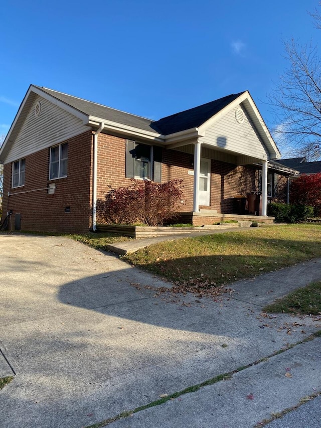 view of side of home with a carport, driveway, and brick siding