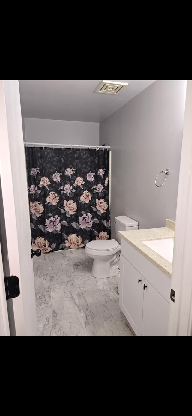 bathroom with marble finish floor, visible vents, a shower with shower curtain, toilet, and vanity