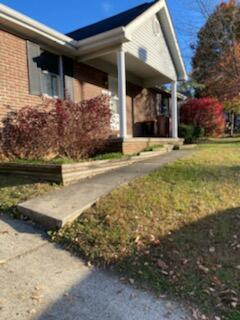 view of side of property with a yard and brick siding