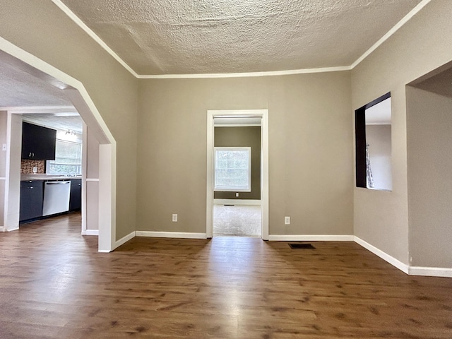 unfurnished room with dark wood-type flooring, a healthy amount of sunlight, and crown molding