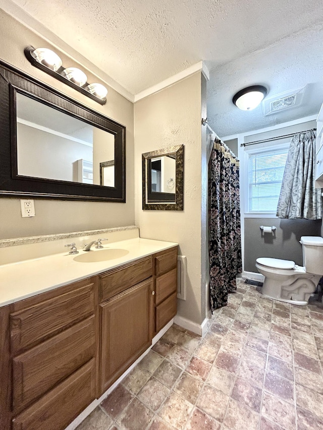 bathroom with vanity, crown molding, toilet, and a textured ceiling