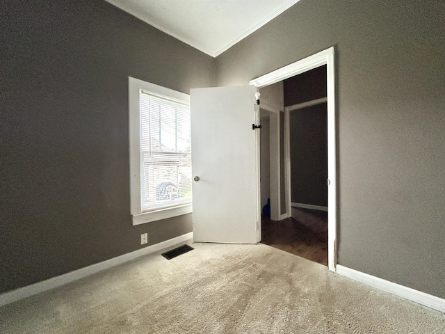 unfurnished bedroom featuring crown molding and carpet floors