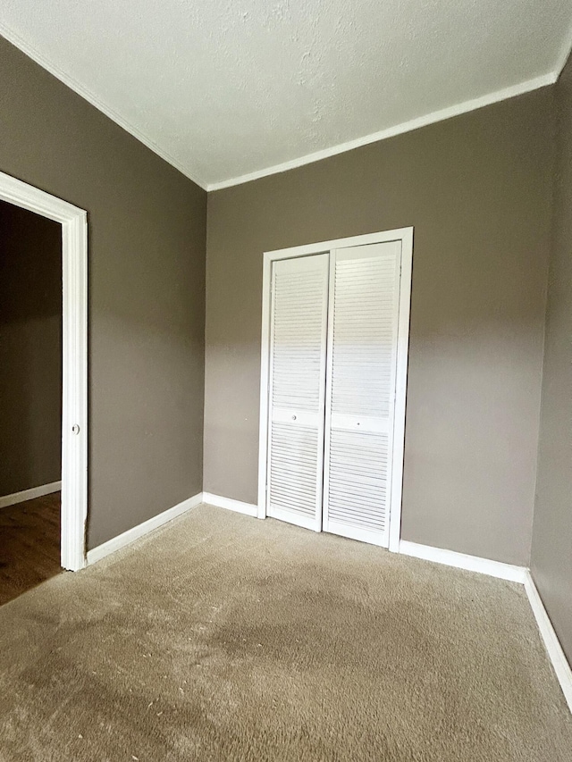 unfurnished bedroom with a closet, a textured ceiling, and carpet