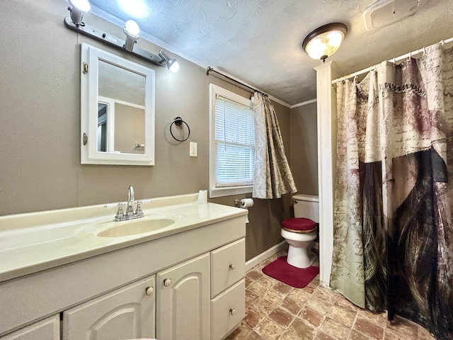 bathroom featuring ornamental molding, vanity, toilet, and a textured ceiling