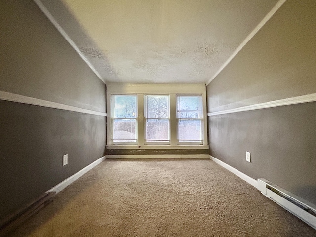 carpeted spare room featuring vaulted ceiling, a textured ceiling, and a baseboard heating unit