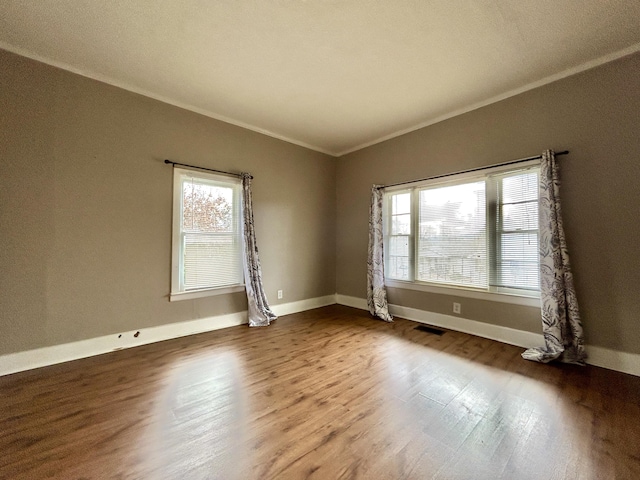 empty room featuring ornamental molding and wood-type flooring