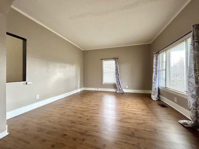 spare room featuring crown molding, dark hardwood / wood-style flooring, and vaulted ceiling